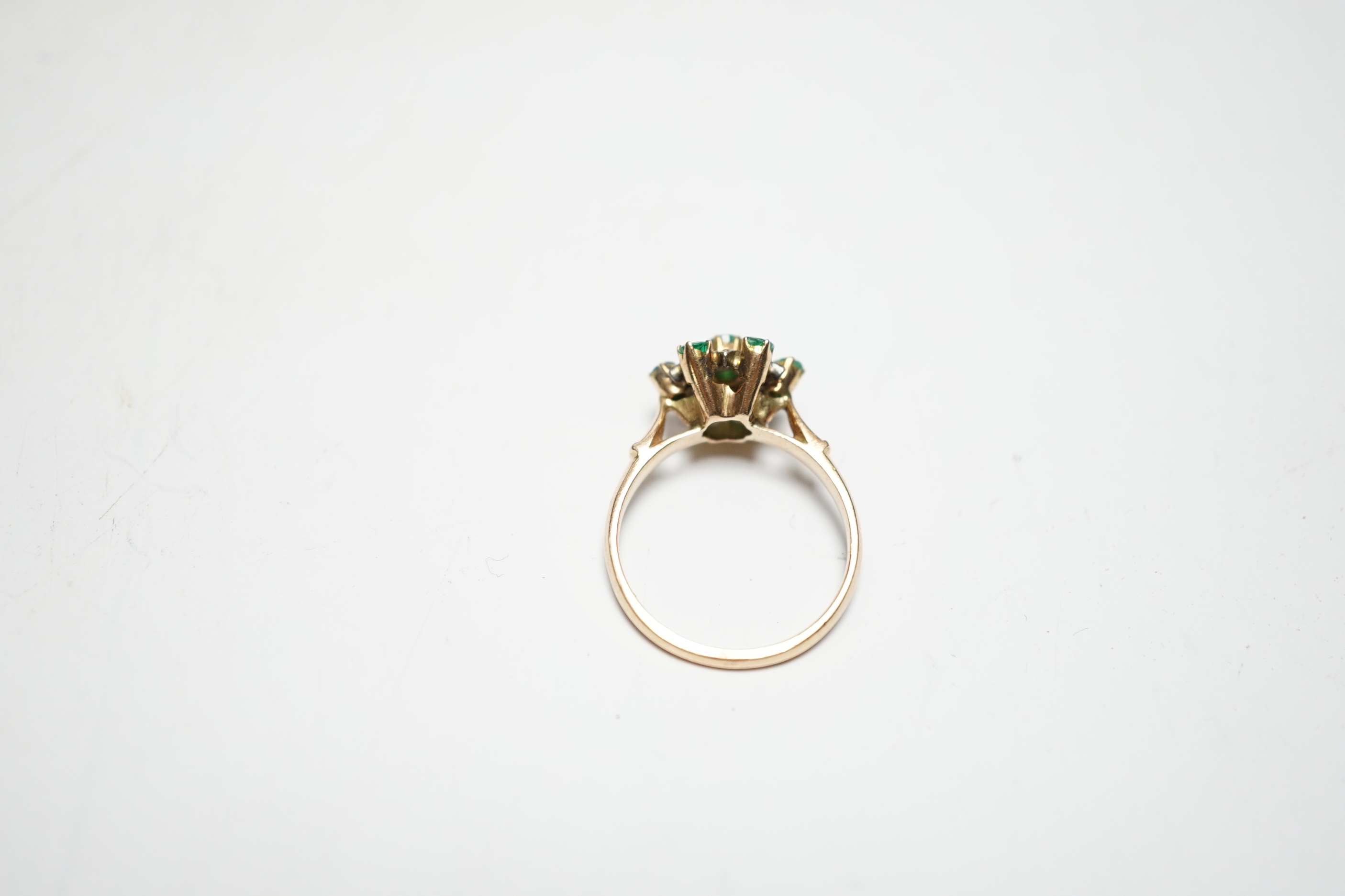 A 14ct, emerald and diamond set flowerhead cluster ring, size N/O, gross weight 3.2 grams.